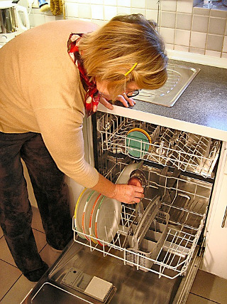 Female preparing a dishwasher for spring cleaning